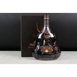 A bottle of Hennessy grande champagne XO Cognac, sealed bottle in box.