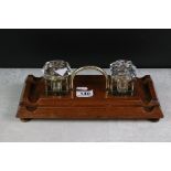 Early 20th Century oak double inkwell desk stand with brass loop handle and square-shaped inkwells