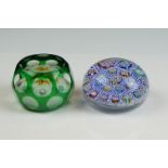 Two Peter McDougal glass paperweights, to include a green overlay faceted example with central