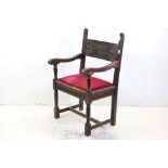 In the manner of Liberty of London, Gothic Revival Oak Elbow Chair with carved back rail and