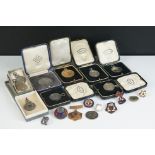 A collection of medals and badges to include sterling silver sports medals.
