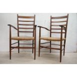 In the manner of Scadart, Pair of Mid century Retro Teak Ladder Back Elbow Chairs with rush seats,