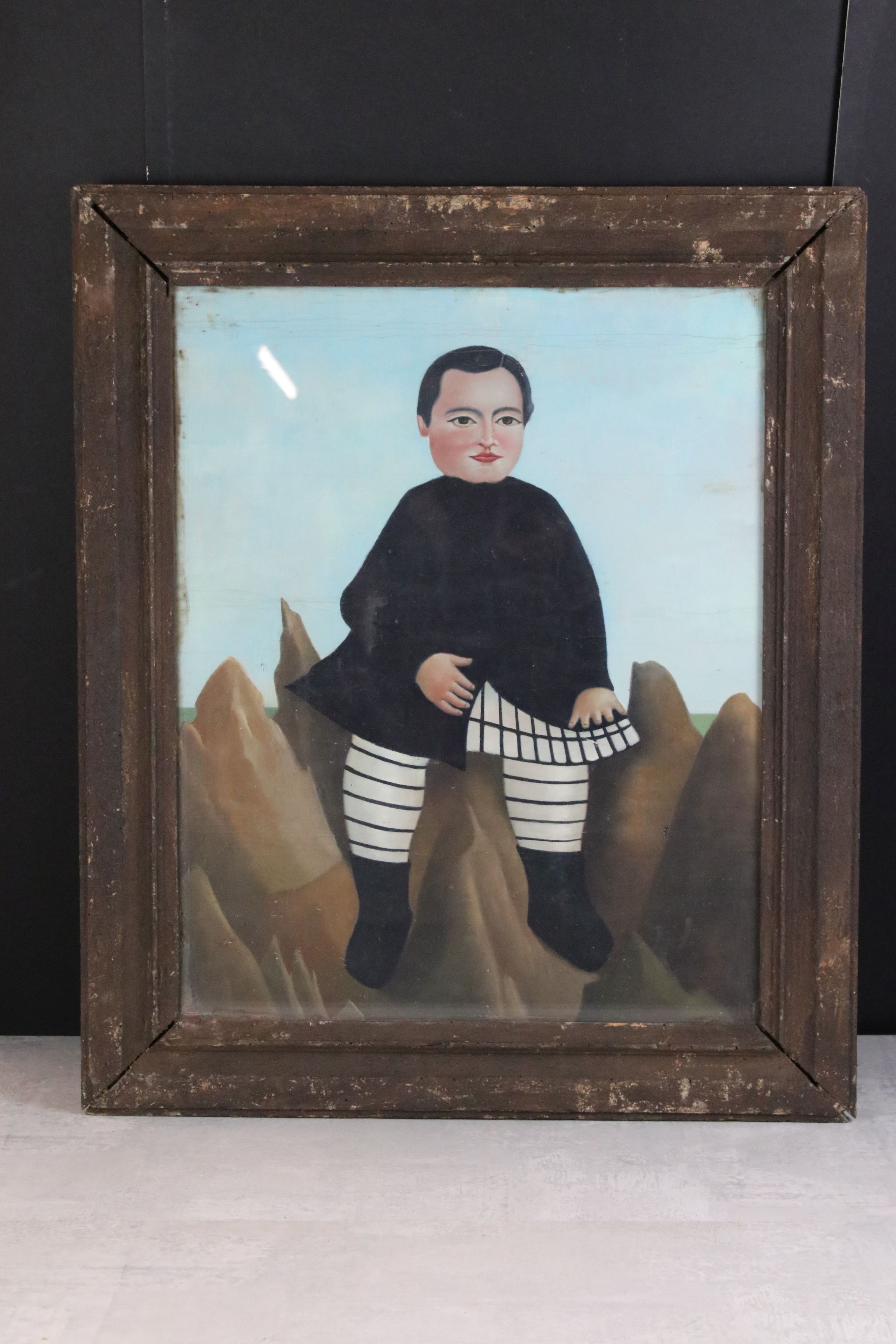 Framed Naive Oil Painting of a Boy seated on Rocks in a Coastal Scene