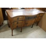 Early 19th century Mahogany and Inlaid Sideboard of serpentine form comprising an arrangement of