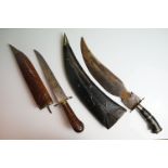 Two asian knives / daggers to include a wood and brass mounted example with carved scabbard.