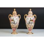 Pair of Royal Bonn Twin Handled Urns with Covers, blush ivory with gilt highlights and decorated
