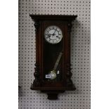 Victorian Walnut Cased Hanging Wall Clock, the white enamel face with Roman numerals and two winding