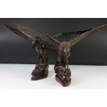 A pair of carved wooden Black Forest style eagles.