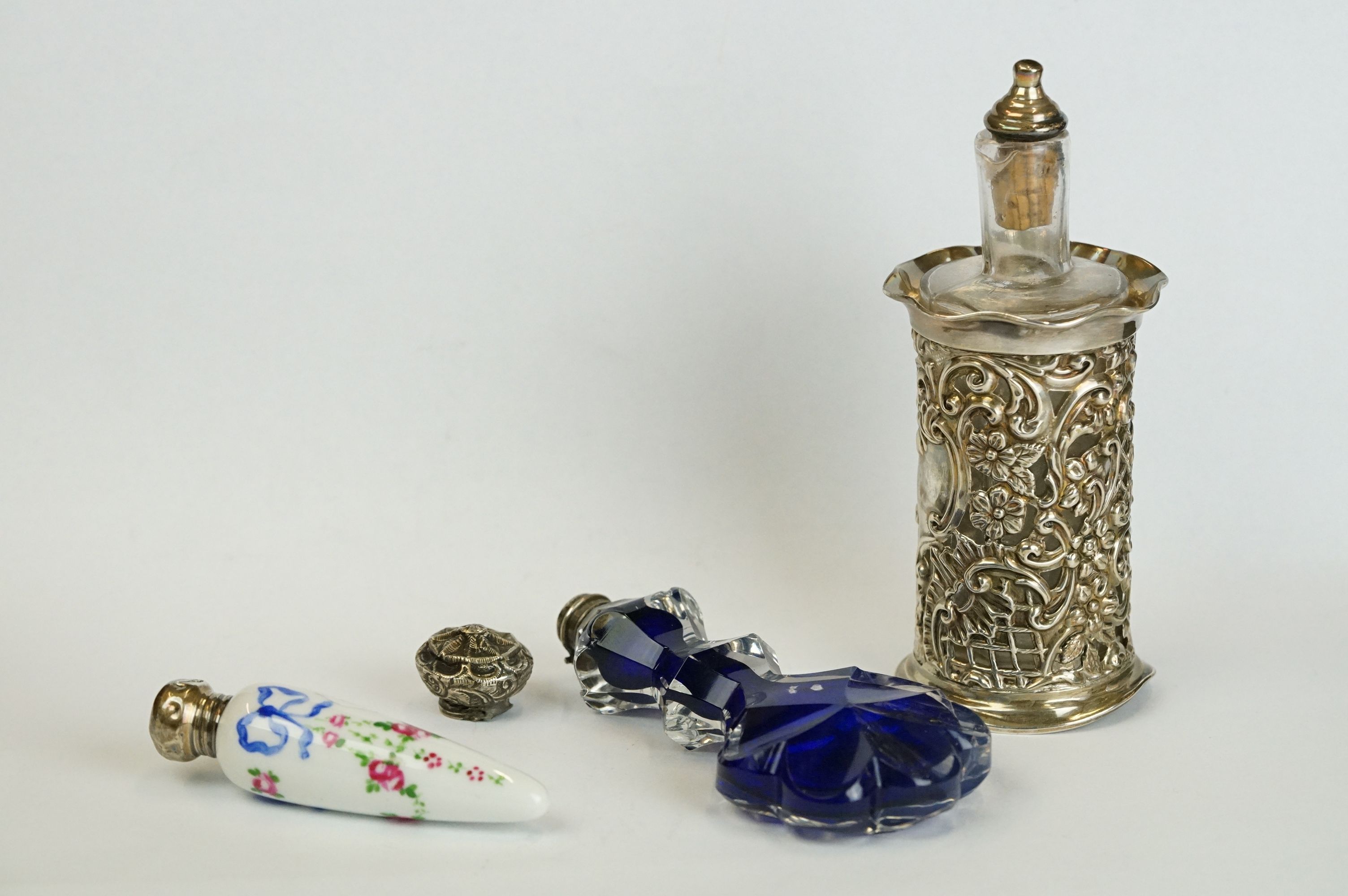 A fully hallmarked sterling silver pierced cased scent bottle together with a blue glass and a