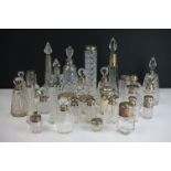 A collection of cut glass silver topped and silver collared scent bottles and vanity jars.