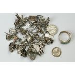 A sterling silver charm bracelet with a good quantity of charms together with a silver ring.