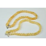 A Yellow Jade necklace with sterling silver clasp together with another similar.