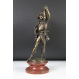A bronze statue of a huntsman on marble plinth marked Lalouette.