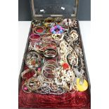 A collection of mainly vintage and contemporary costume jewellery contained within a glass topped