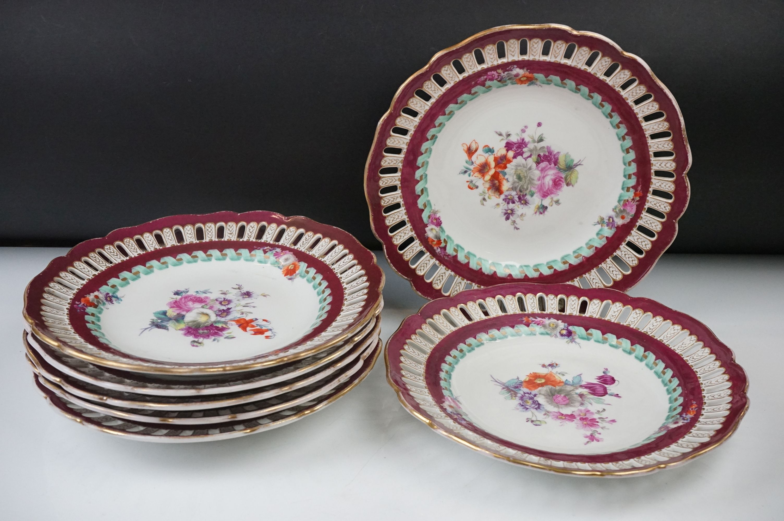 Seven Meissen reticulated Plates decorated with sprays of flowers within a ribbon border and pierced