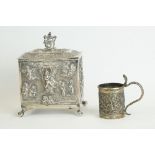 An antique white metal tea caddy with hinged lid and angelic repousse decoration together with a