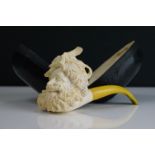 A cased Meerschaum smokers pipe with carved head bowl and yellow amber mouthpiece.