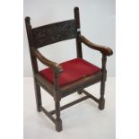 In the manner of Liberty of London, Gothic Revival Oak Elbow Chair with carved back rail and