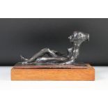 Bronze effect Figure of a recumbent nude woman raised on a wooden plinth, 19cm long