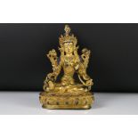 A cast metal seated Buddha with gilt decoration.