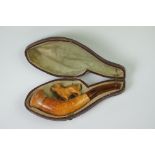 An antique meerschaum pipe with carved dog within original fitted case.