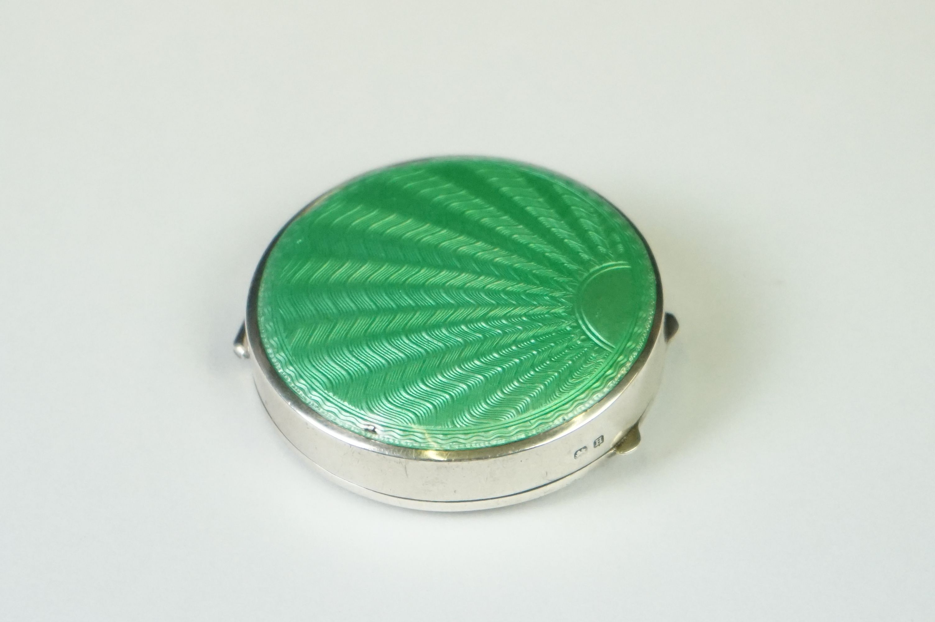 A fully hallmarked sterling silver and enamel Art Deco powder compact with green guilloche