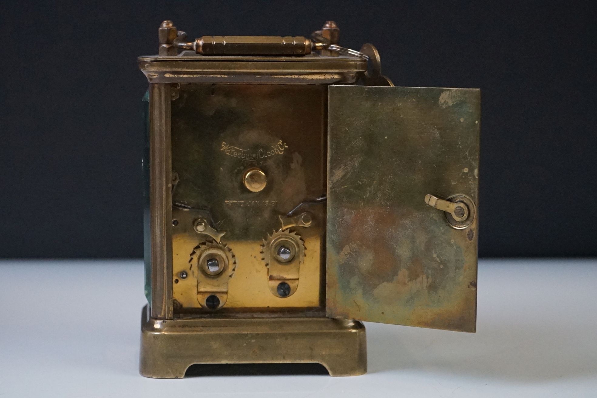 A brass cased carriage clock with beveled glass panels and white enamel dial, complete with key. - Image 6 of 15