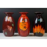 Three Anita Harris Studio baluster vases to include an example with flame-like design on ox blood