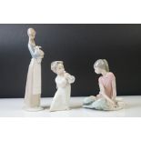 Three Lladro Porcelain Figures to include a seated ballerina, girl holding lamb and an angel with