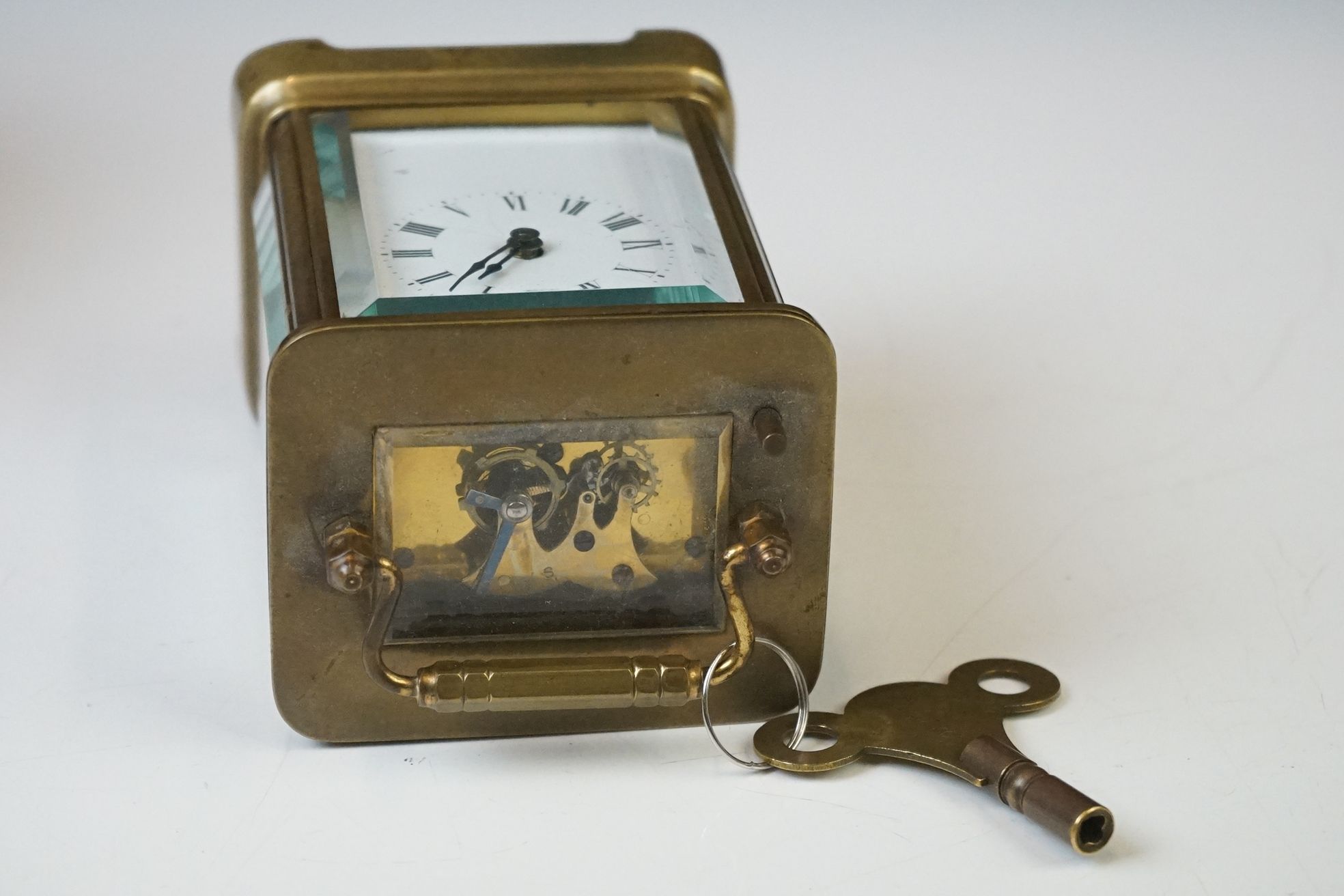 A brass cased carriage clock with beveled glass panels and white enamel dial, complete with key. - Image 12 of 15