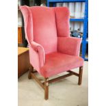 Edwardian Wingback Armchair in the George III manner, upholstered in pink fabric, raised on square