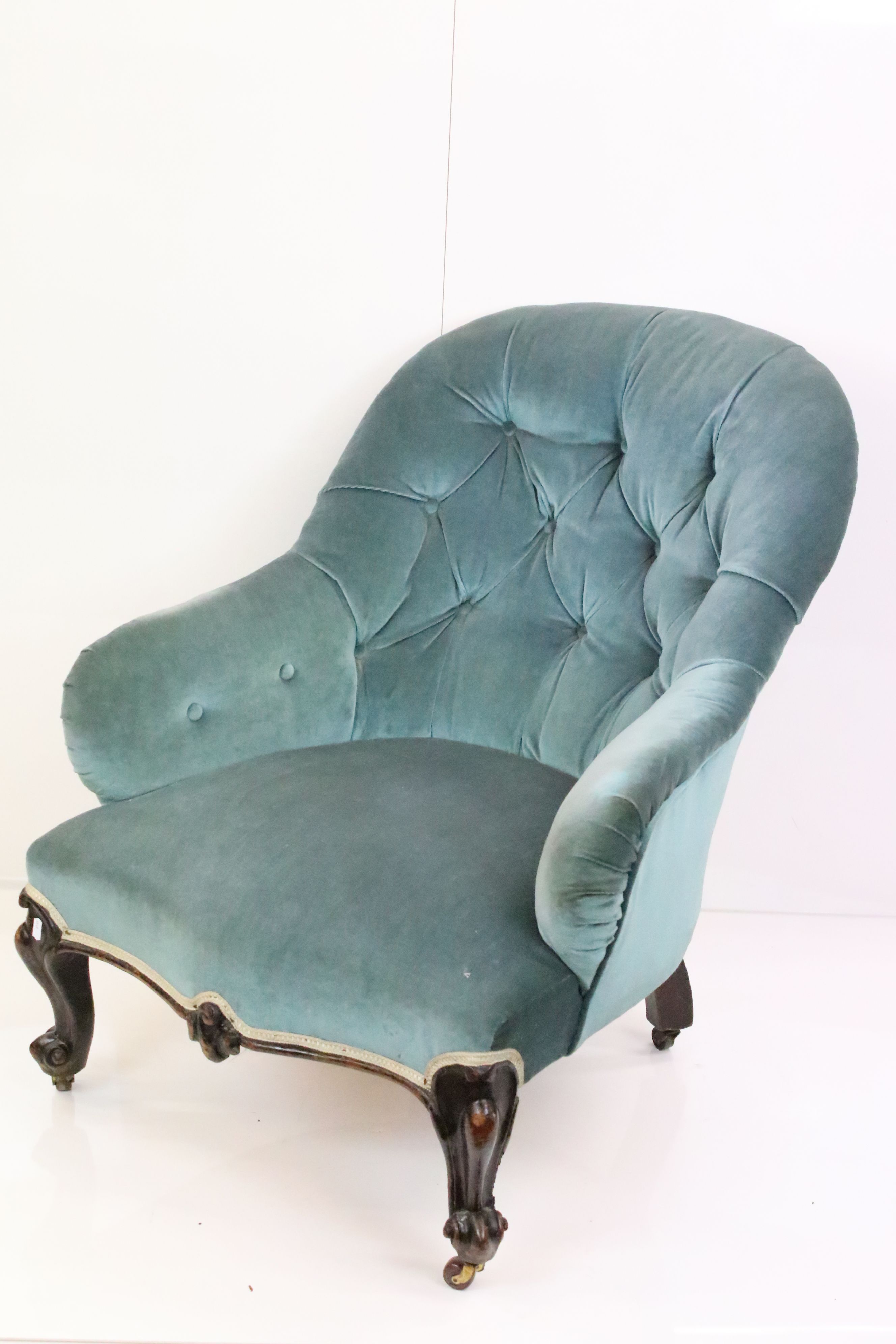 Victorian Button Back Armchair upholstered in blue fabric, raised on carved scrolling front legs