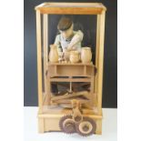 Cased Mechanical Wooden Automaton of a Potter at his Wheel, the cased inscribed with a monogram,