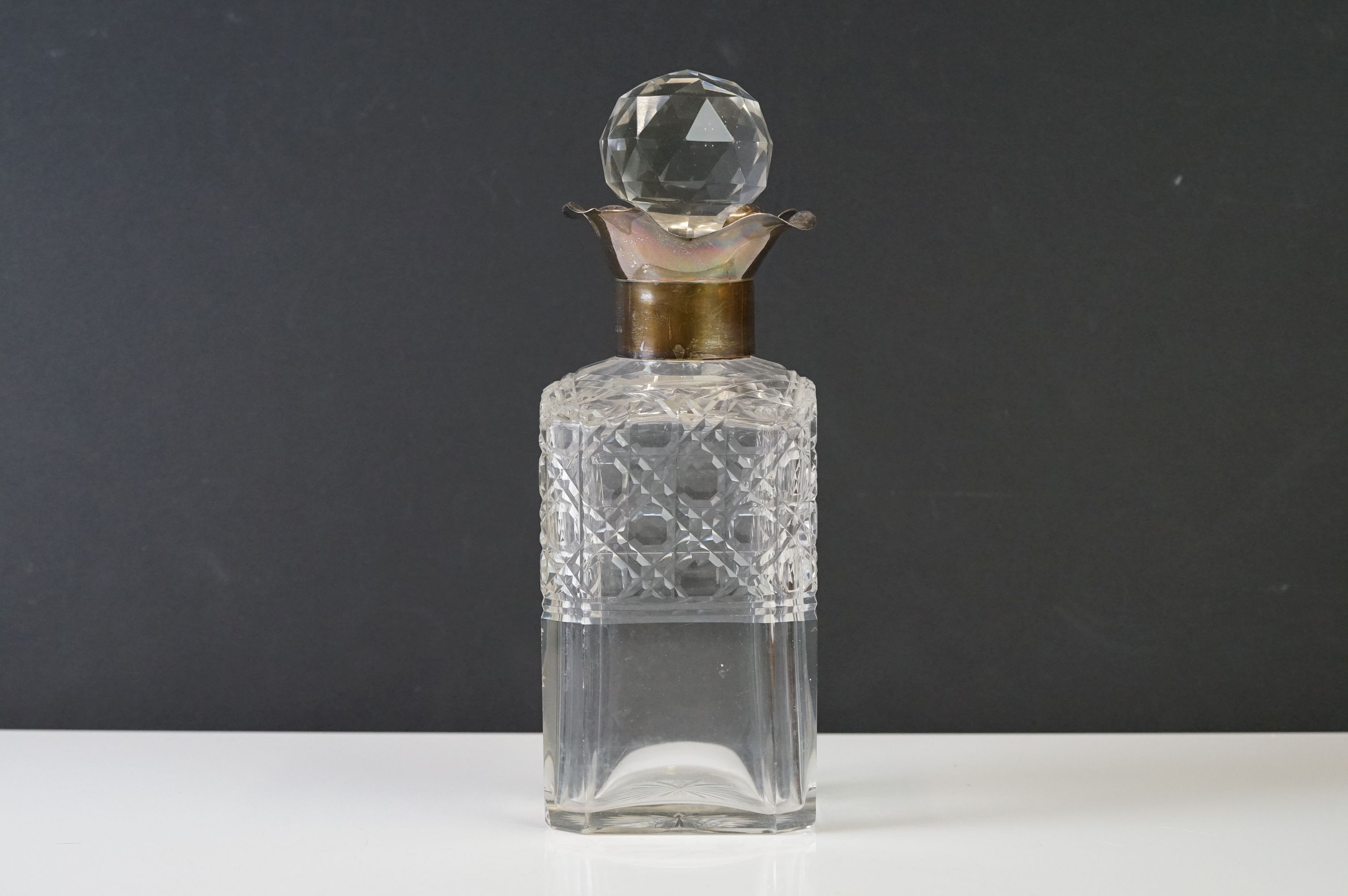 A cut glass decanter with fully hallmarked sterling silver collar, assay marked for London and dated