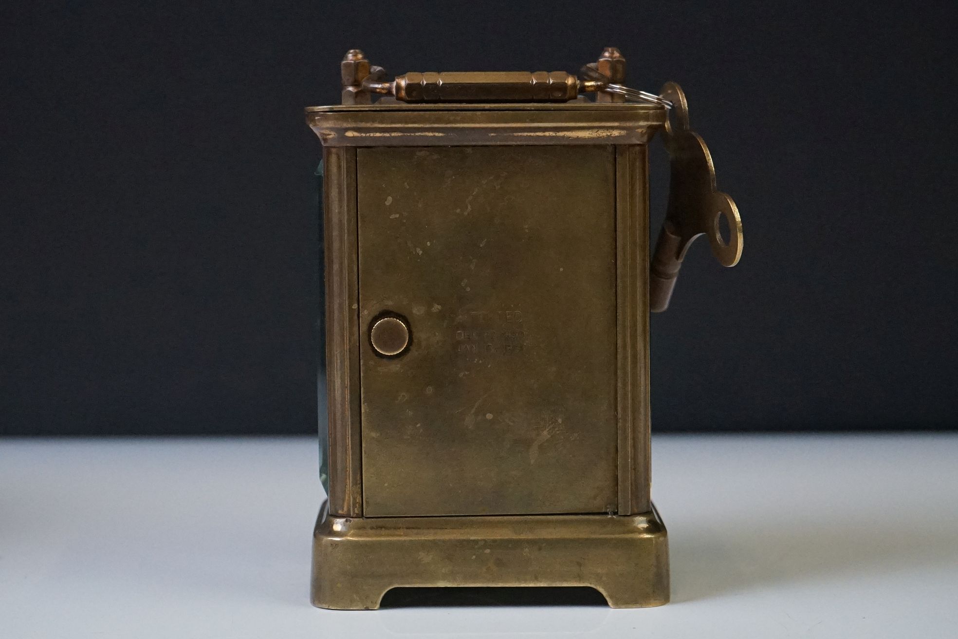 A brass cased carriage clock with beveled glass panels and white enamel dial, complete with key. - Image 4 of 15