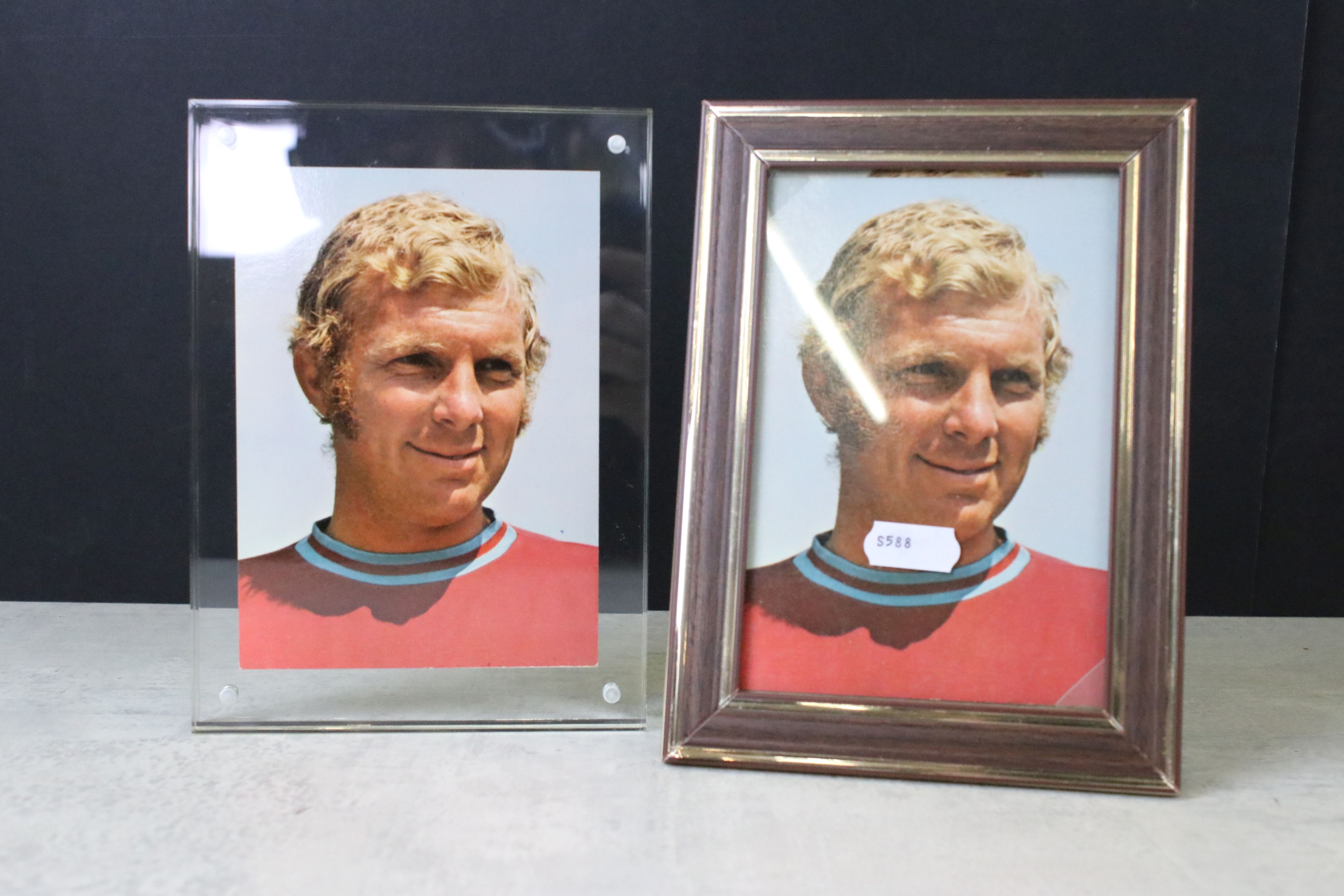 A signed Bobby Moore postcard mounted within a clear framed together with an unsigned example.