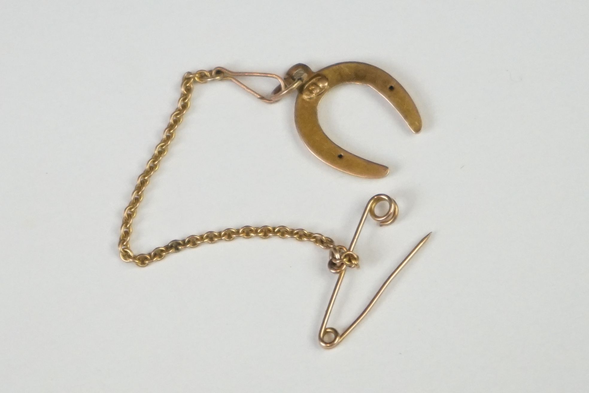 A small yellow metal lucky horse shoe with safety chain attachment. - Image 3 of 6