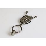 An antique Victorian white metal skirt lifter.