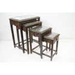 Nest of Four South East Asian Stained Wooden Tables, the top carved with scenes of boats with