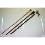 Three Folk Art wooden walking sticks to include a Black Forest style example with carved figural