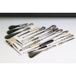 A collection of antique button hooks and shoe horns to include hallmarked sterling silver examples.