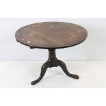 George III Oak Circular Tilt Top Supper Table raised on a turned column and three splayed legs, 88cm