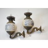 Pair of advertising brass wall oil lamps, the bulbous ceramic wells printed with advertisements