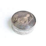 A vintage white metal powder jar with figural decoration to the lid and foliate decoration to the