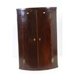 Early 19th century Mahogany and Boxwood Inlaid Bow Front Hanging Corner Cupboard, the two doors