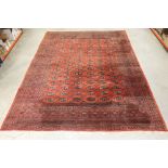 Large Red Ground Wool Rug, the centre decorated with rows of guls within a deep border, 370cm x