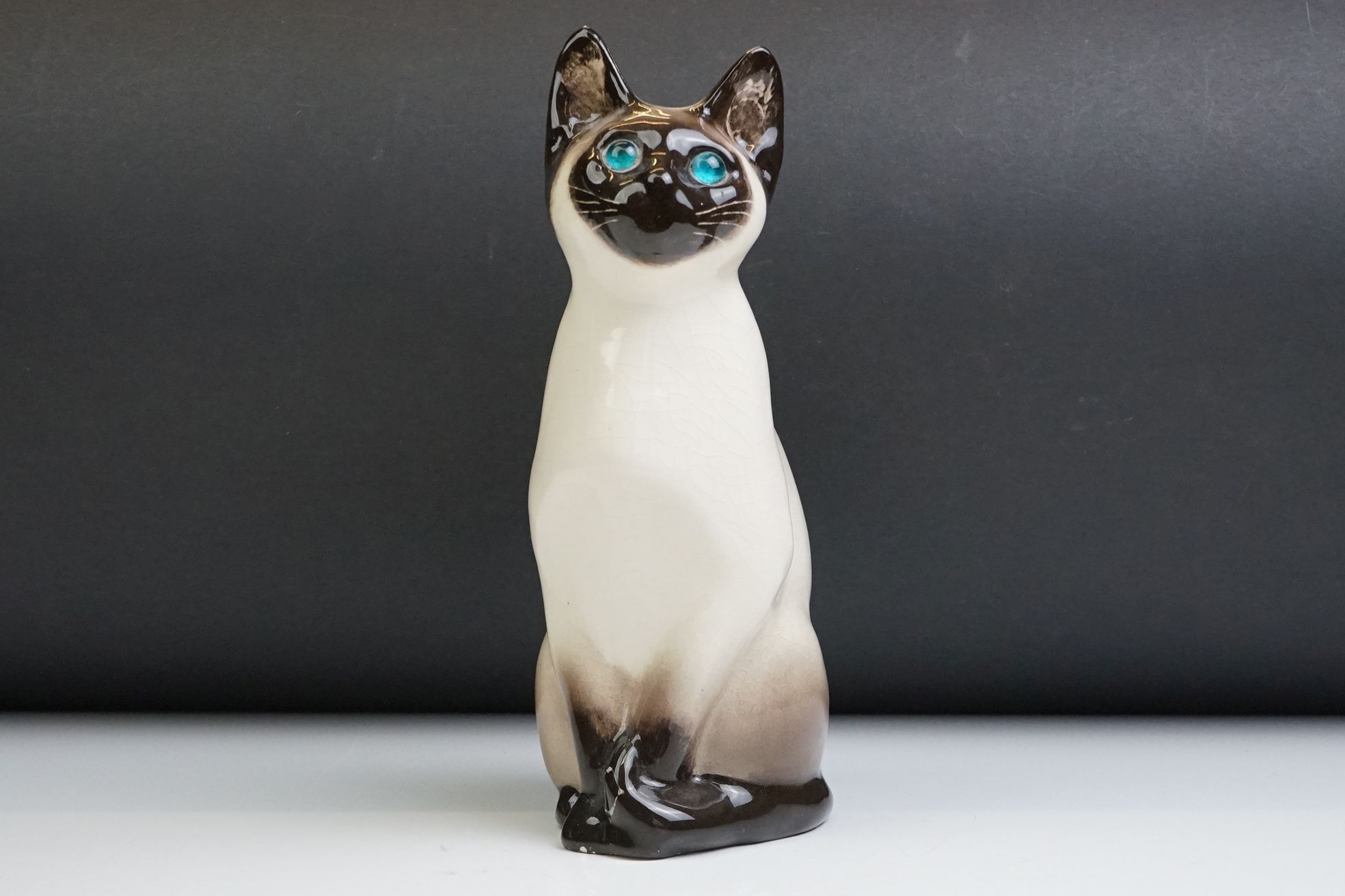 Winstanley pottery figure of a seated Siamese cat, with blue glass eyes, numbered 34, signed '