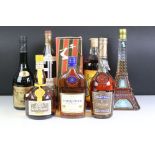 A small collection of bottled alcohol to include Courvoisier, Grand Marnier and Martell.