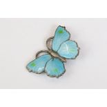A sterling silver butterfly brooch with blue enamel decoration.