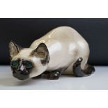 Winstanley pottery figure of a crouching Siamese cat with blue glass eyes, signed to the base and